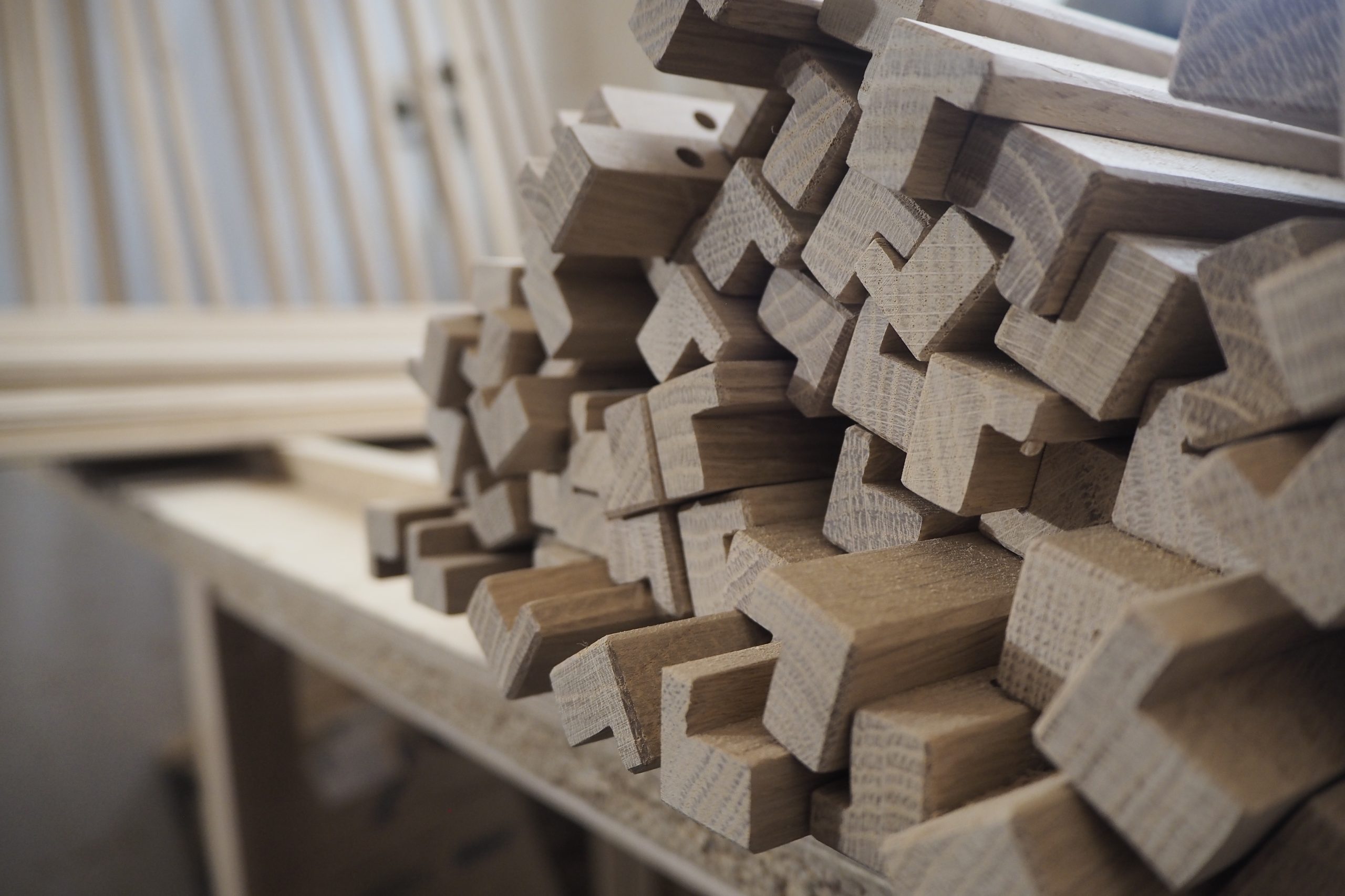 Stos drewnianych uchwytów meblowych, ułożonych na stole