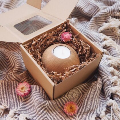 Box prezentowy, zawierający drewniany świecznik w formie kuli ze świecą tealight, zapakowany w eko pudełko z okienkiem. Ozdobiony suszonymi kwiatami.